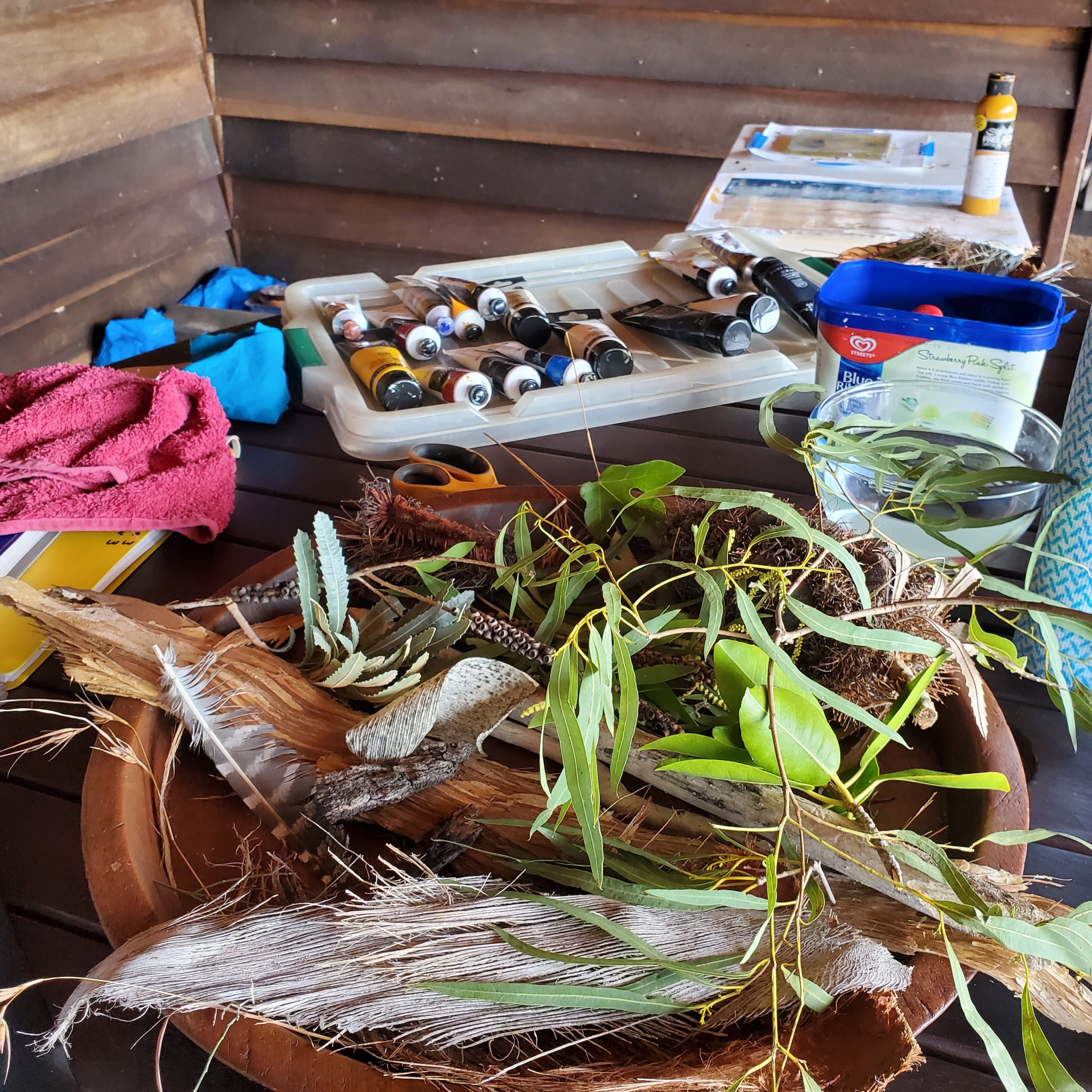Collected plants and paints on table in preparation for printmaking.
