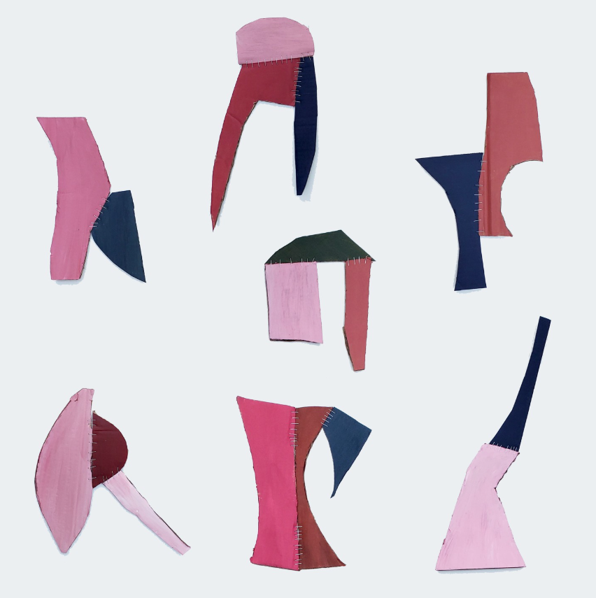 Cardboard hieroglyphs painted in shades of pink and navy blue